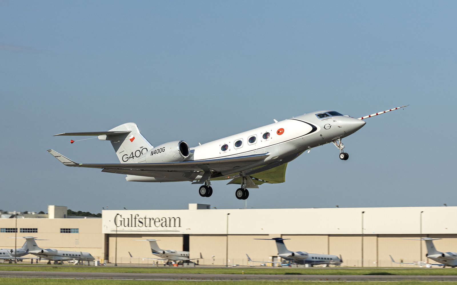 The Gulfstream G400 flight-test aircraft N400G climbing past a Gulfstream facility